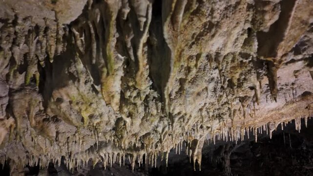 Limestone stalactites inside a dark cave
