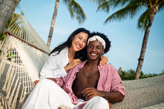 Happy couple having fun at the beach, playing and laughing together in a romantic tropical setting