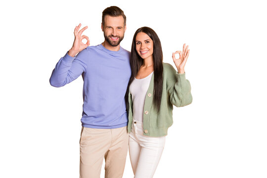 Photo of optimistic couple stand show okey wear sweater pants isolated on beige color background