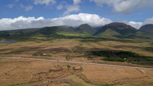 Aerial panning left with views of Mauna Kahalawai near Lahaina in West Maui, Hawaii. Sunny afternoon during spring in April, 2023. Overlooking highway 3000, the Lahaina bypass of highway 30.