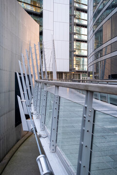 Modern pedestrian walkway with glass railing and contemporary architecture in Paris France creates a clean urban passage between office buildings