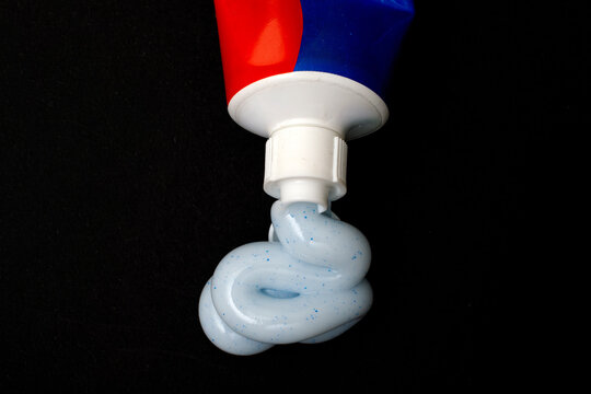 Toothpaste squeezed out of a tube on a black background for a dentistry and dental health concept, high quality photo