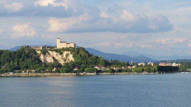 View of Rocca di Angera medieval fort on rocky outcrop from over Lake Maggiore