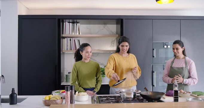 Diverse female co-hosts introducing on camera then cooking on marble island with pot, wok