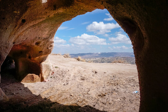Cappadocia valley view framed by ancient cave opening and stone window