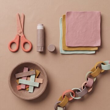 Kinderschere Klebestift und Papierkette als Bastelmaterial von oben