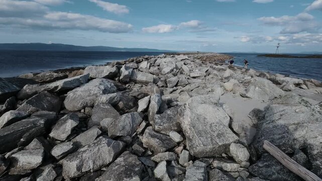 Granite breakwater boulders by the calm Trondheimsfjord near Trondheim