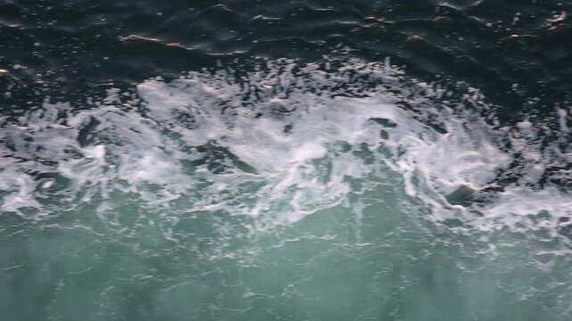 Slow motion top view of ocean waves and foam