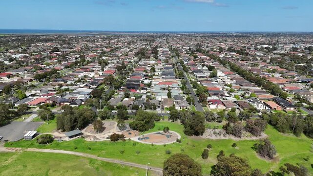 Aerial view of local parklands, playground areas, and sports grounds bordering houses, structured suburban residential housing grids in Altona Meadows, Melbourne, Victoria, Australia