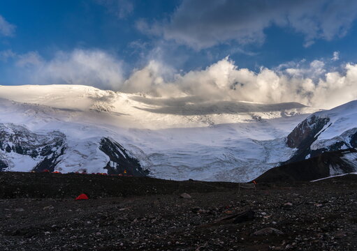 Lenin Peak north wall at sunset with camp tents, August