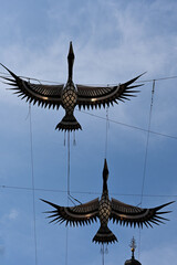 Fototapeta premium Artistic installation of construction cranes rising above the historic Old Town of Lublin, Poland, contrast between contemporary public art and traditional architecture. Poland, Lublin - May 10 2026