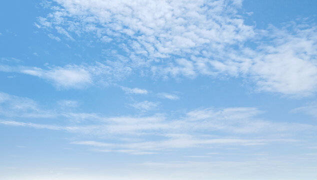 Bright blue sky with soft, wispy clouds drifting slowly