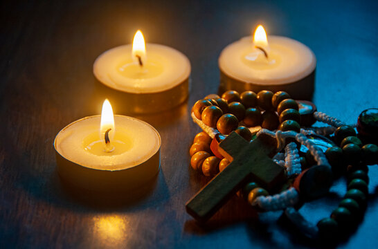 Holy Rosary with bright candle light background.