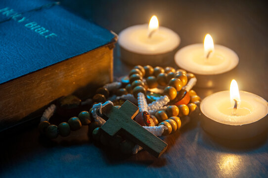 Glowing candles beside a wooden crucifix representing faith and spiritual devotion with customizable space for text.