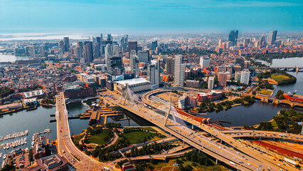 Obraz premium Aerial view of Zakim Bridge and highway interchange in Boston. A cable stayed bridge crosses river near road junction in Boston, USA.