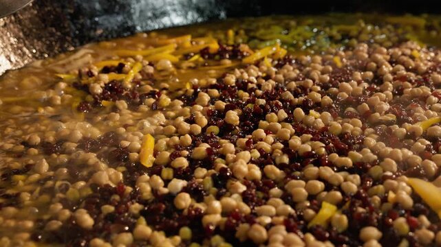 Boiling zirvak for traditional Uzbek wedding plov. Zirvak with chickpeas, carrots and spices boils in a large kazan during the preparation of traditional Uzbek wedding plov. Authentic Central Asian