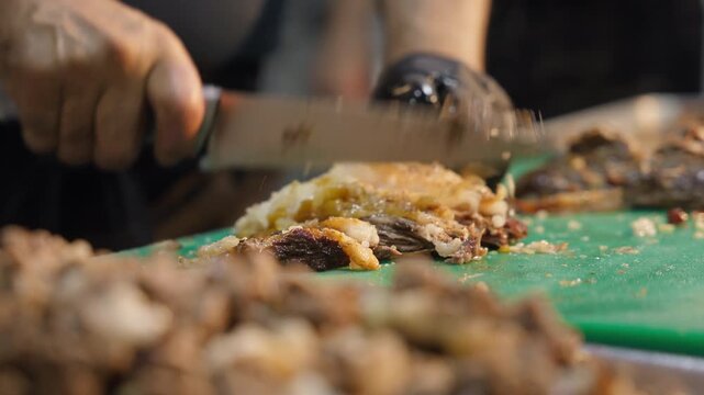 Close-up of a cook slicing meat for traditional Uzbek plov during the preparation process. Authentic Central Asian culinary. Food documentaries, tourism, travel