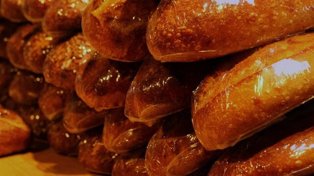 Wholegrain breads wrapped with plastic foil stacked on table closeup. Delicious healthy loaves made in craft bakery shop. Small business