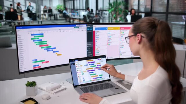 Project Manager Reviews Gantt Chart On Laptop