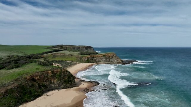 4K Aerial Drone View of Stunning Coastal Landscape with Ocean Waves, Green Hills and Clear Blue Sky