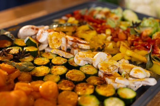 Roasted vegetables are glistening on baking sheet in kitchen, showing zucchini, mushrooms, peppers