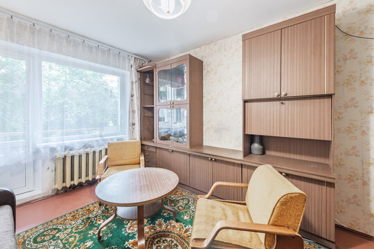 Vintage Soviet-Era Living Room With Wooden Wall Unit, Yellow Armchairs and Patterned Rug