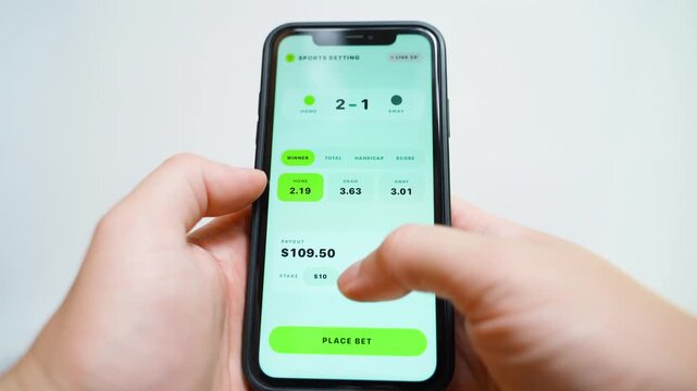 Hands holding smartphone with sports betting app showing live odds and payout