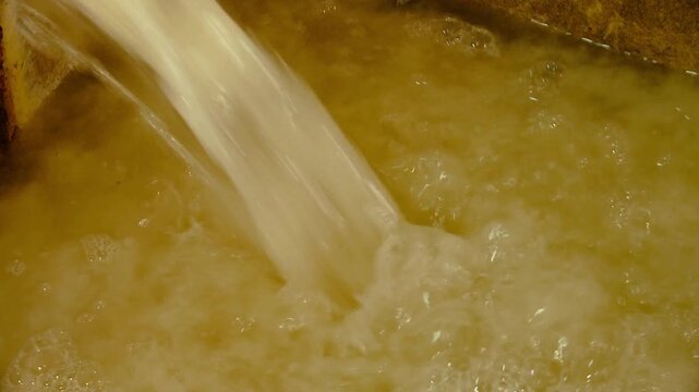 Paper pulp water flowing in tub traditional chinese paper mill.