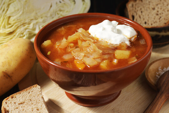 A bowl with traditional Russian cabbage soup shchi served in rustic style