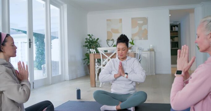 Three women mirroring African-American leader raising arms, guiding breathing on yoga mats at home