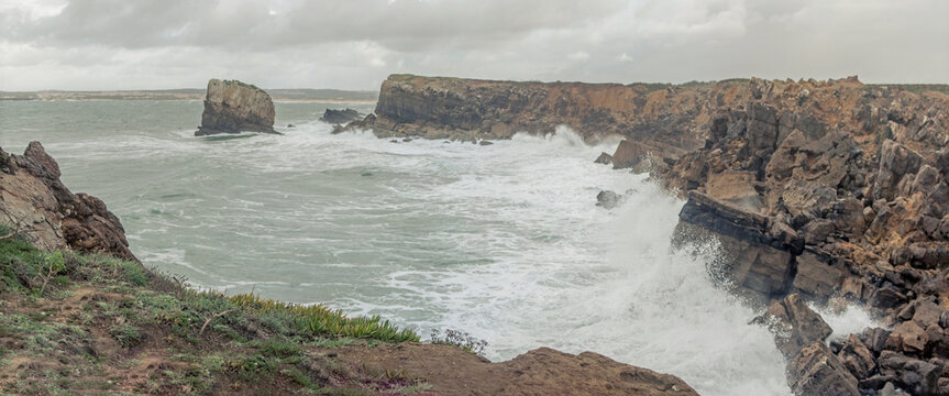 Waves crashing against rocky cliffs at Papoa in Peniche Portugal