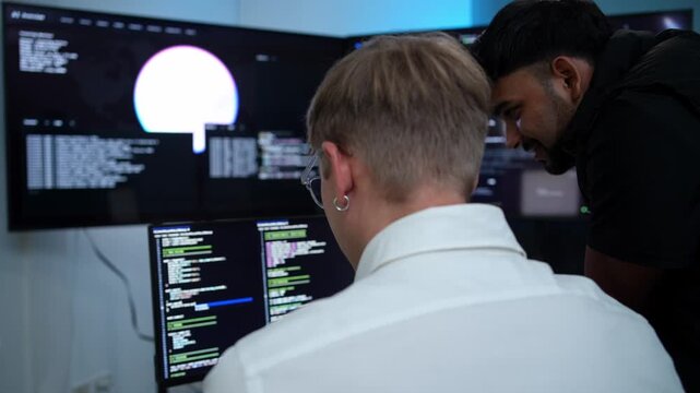 Two developers collaborating on code debugging with advanced monitors in a high tech environment