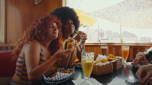 Cinematic footage about a group of multi-ethnic friends eating and having fun in an american styled diner restaurant.