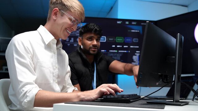 Collaborative programming session two coders working together on computer screens in a modern office environment