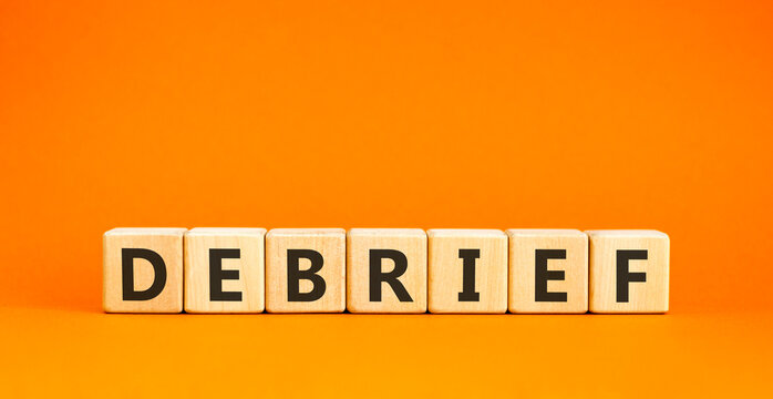 Debrief word symbol. Concept word Debrief on beautiful wooden blocks. Beautiful orange table orange background. Business debrief word concept. Copy space.