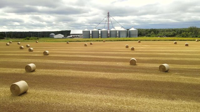 Low altitude aerial pull back over straw bales in PEI field, Canada