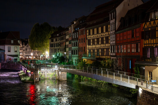 Illuminated half-timbered houses and canal at night in Petite France, Strasbourg, Alsace, France