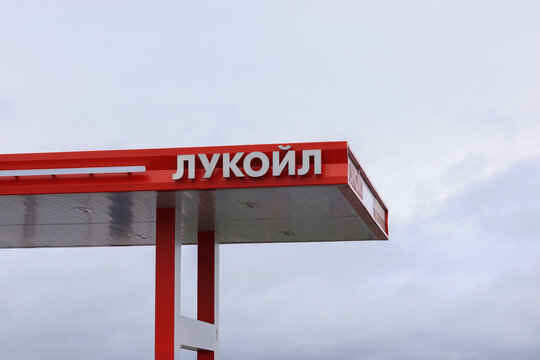 Lukoil fuel station canopy with red branding against an overcast sky, petroleum retail infrastructure, energy business, roadside service, fuel industry, commercial location.