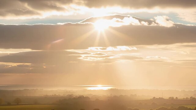 Serene landscape with soft sunlight breaking through clouds illuminating nature