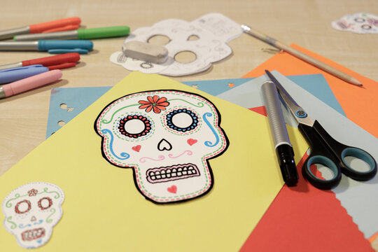 Handmade Day of the Dead paper skull with colorful craft supplies