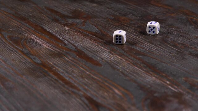 Close-up of a hand throwing dice on a wooden table