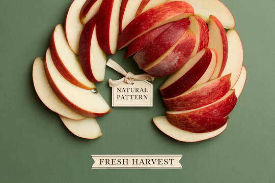 Fresh red apple slices arranged in a circular pattern on a green background. A small tag reads 'Natural Pattern'.