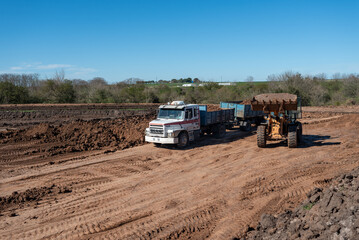 Heavy machinery fleet and trucks working at earthmoving and land leveling site © MatiasLeonel