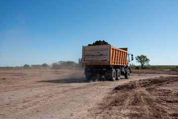 Dump truck loaded with soil driving at outdoor construction site © MatiasLeonel