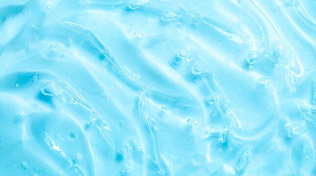 Cosmetic gel, serum, clear sample with a blue tint, close-up. Liquid cream with a foaming texture. Gel texture of a cosmetic product. Liquid cosmetic lotion for skin care.