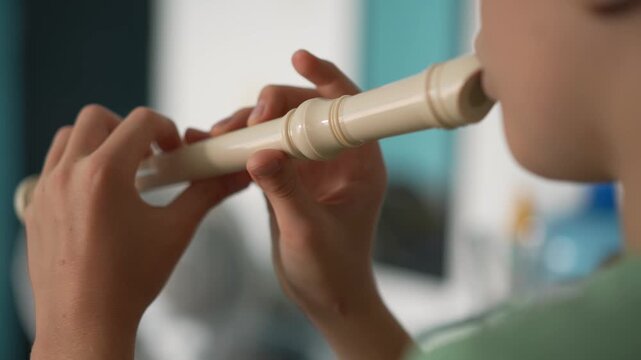 A little boy learns to play the flute at home, practicing with focus and enthusiasm in a cozy, warm setting. A charming scene of early musical exploration, creativity, and childhood growth.