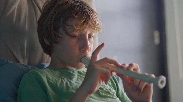 A little boy learns to play the flute at home, practicing with focus and enthusiasm in a cozy, warm setting. A charming scene of early musical exploration, creativity, and childhood growth.