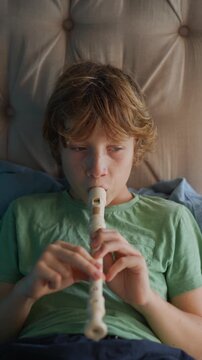 A little boy learns to play the flute at home, practicing with focus and enthusiasm in a cozy, warm setting. A charming scene of early musical exploration, creativity, and childhood growth.