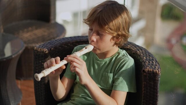 A little boy learns to play the flute at home, practicing with focus and enthusiasm in a cozy, warm setting. A charming scene of early musical exploration, creativity, and childhood growth.