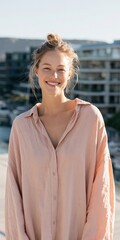 Obraz premium Young woman smiling in soft pink blouse rooftop portrait for lifestyle background and banner design showcasing natural sunlight and casual fashion